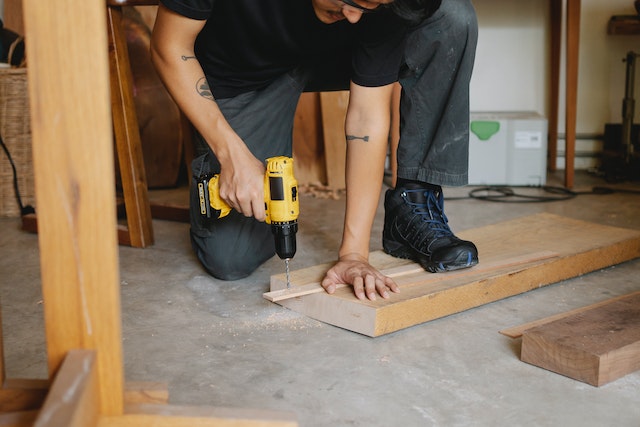 contractor using a drill on a piece of wood